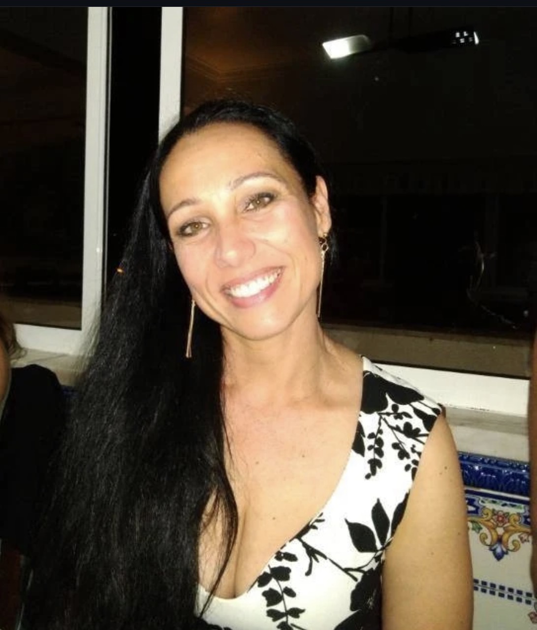 Tatiana Menezes, terapeuta e mentora do Código M40+, sorrindo em seu escritório